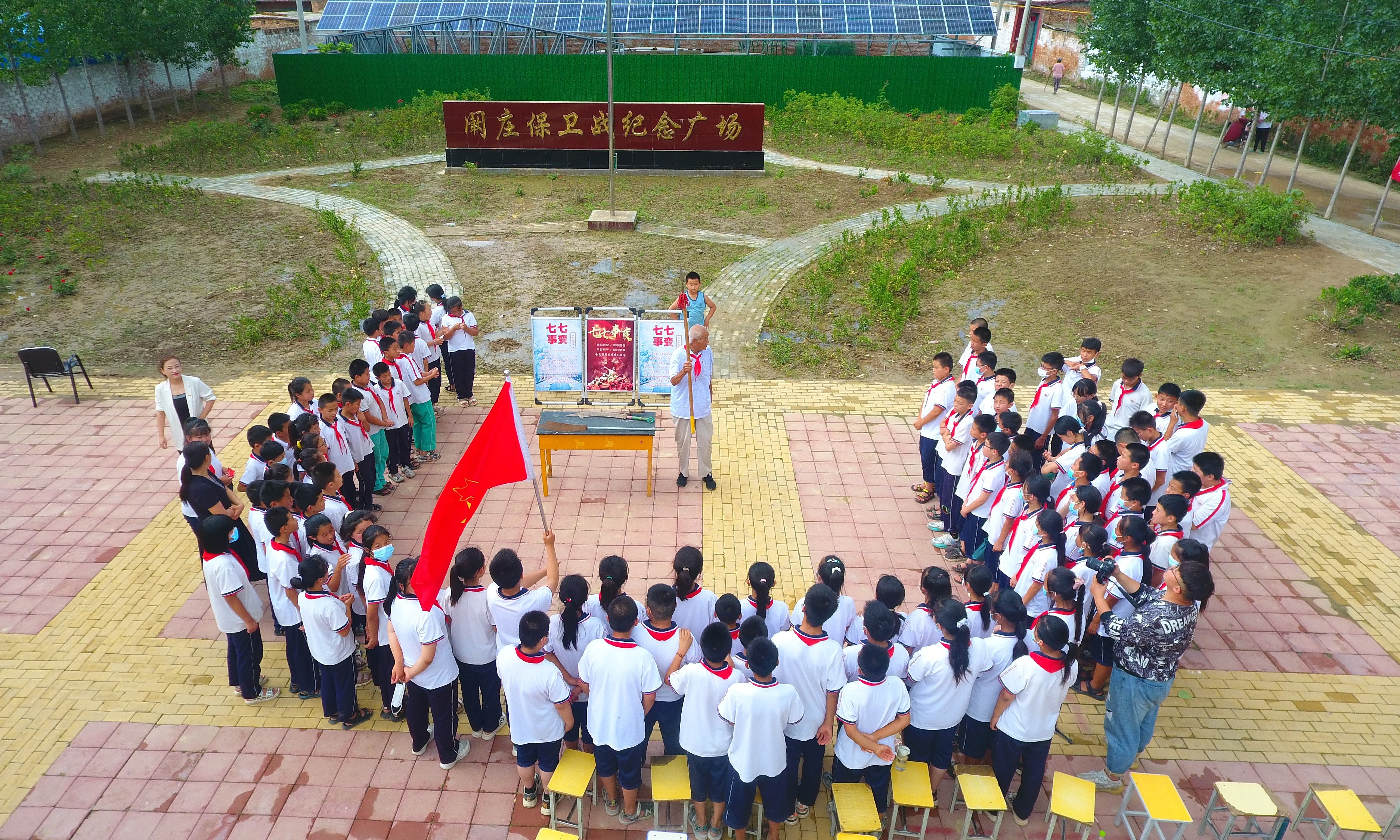 2022年7月6日，山東省聊城市，在茌平區(qū)菜屯鎮(zhèn)闞莊村的闞莊保衛(wèi)戰(zhàn)紀(jì)念廣場(chǎng)，闞莊保衛(wèi)戰(zhàn)親歷者王光木老人，為小學(xué)生們講述抗戰(zhàn)故事，展示大刀、長(zhǎng)矛。